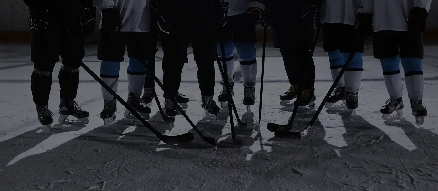 Hockey players lined up on the ice with their sticks down